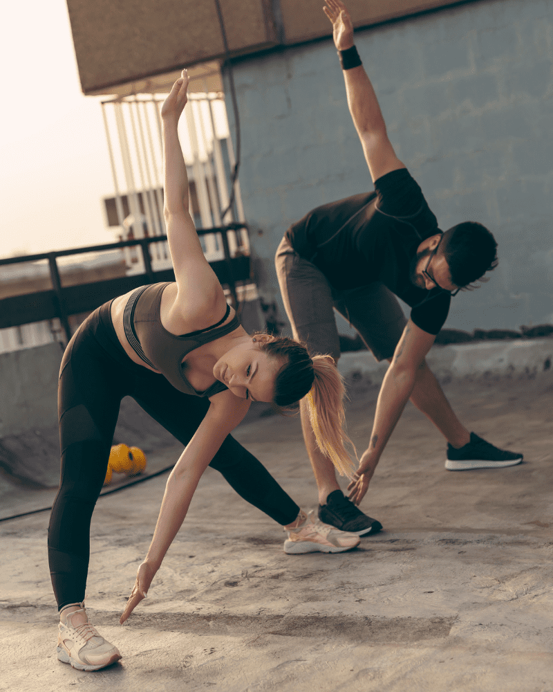 Woman and man stretching working on ankle and hip mobility in order to improve lower back pain with squats